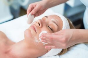 Imagem de uma mulher fazendo tratamento facial esfoliação