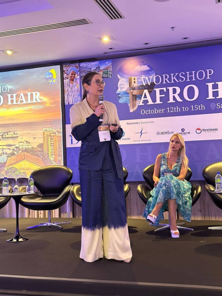 a imagem mostra a Drª Christine, da Graf Guimarães, em palestra no Workshop Afro Hair 2023